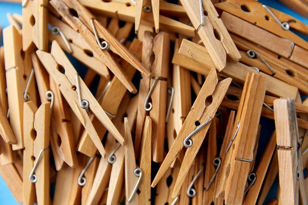 Close up of wooden clothespins on blue background — Stock Photo, Image