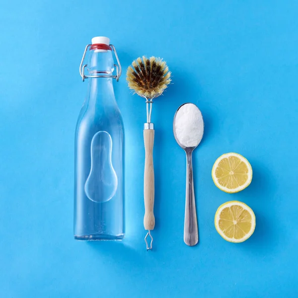 lemons, washing soda, bottle of vinegar and brush