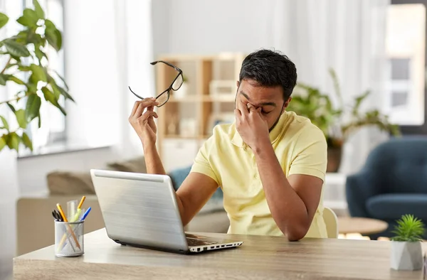 Втомлений чоловік з ноутбуком працює в домашньому офісі — стокове фото
