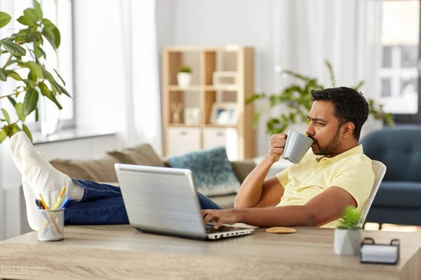 Pria dengan laptop minum kopi di kantor rumah — Stok Foto