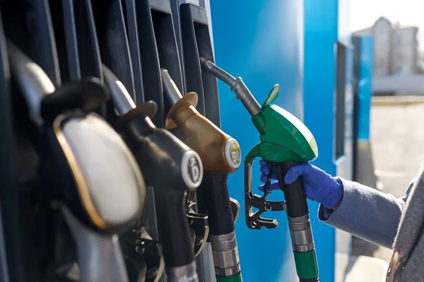 Close up of hand in glove with gas nozzle — Stock Photo, Image