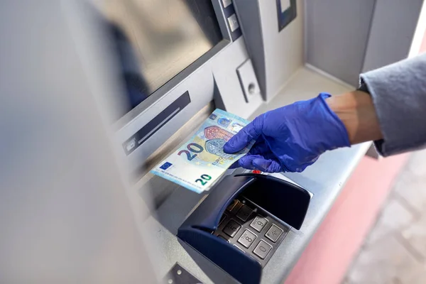 Mano en guante médico con dinero en cajero automático — Foto de Stock