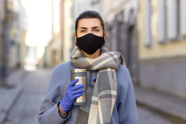 Женщина в маске многоразового использования с тумблером в городе — стоковое фото