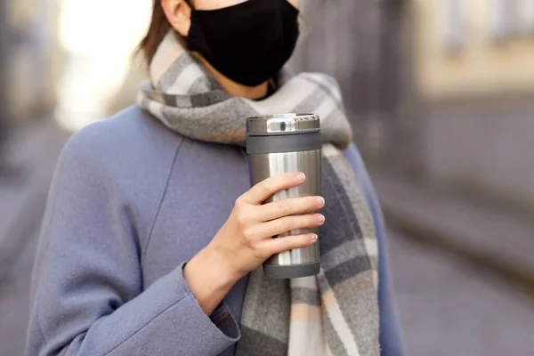 Femme en masque réutilisable avec gobelet en ville — Photo
