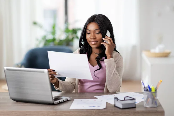 Mujer con papeles llamando por teléfono en la oficina en casa —  Fotos de Stock