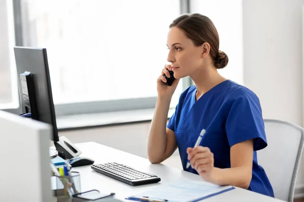 Médecin avec ordinateur appelant au téléphone à l'hôpital — Photo