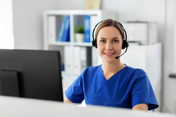 Doctor with headset and computer at hospital — Stock Photo, Image