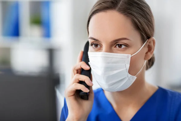 Lékař s počítačem volat na telefon v nemocnici — Stock fotografie