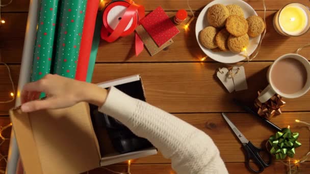 Mujer envoltura cámara para regalo de Navidad — Vídeos de Stock