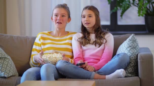 Meninas adolescentes comendo pipoca assistindo tv em casa — Vídeo de Stock