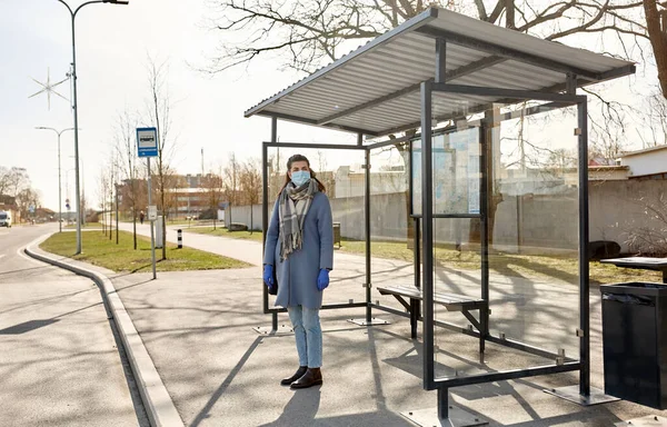 Mladá žena nosí lékařskou masku na autobusové zastávce — Stock fotografie