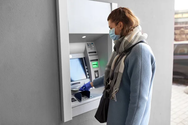 Mão em luva médica com dinheiro na máquina ATM — Fotografia de Stock