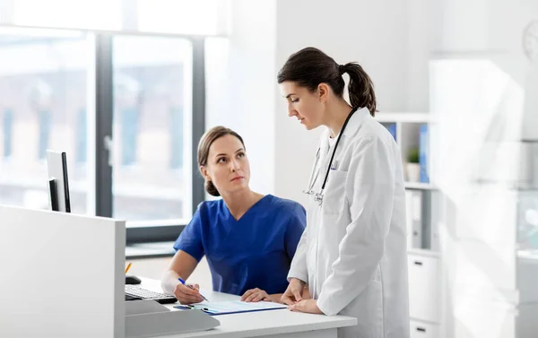 Doctor and nurse with clipboard at hospital — Stock Photo, Image