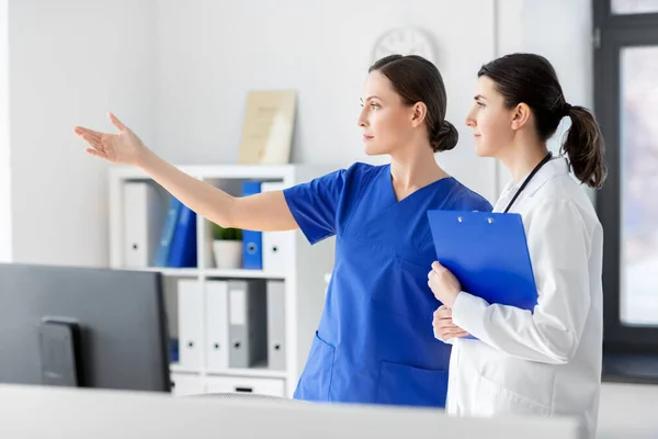 Медсестра показывает что-то доктору в больнице — стоковое фото