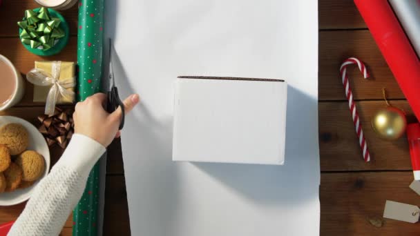 Mains enveloppant cadeau de Noël dans du papier à la maison — Video