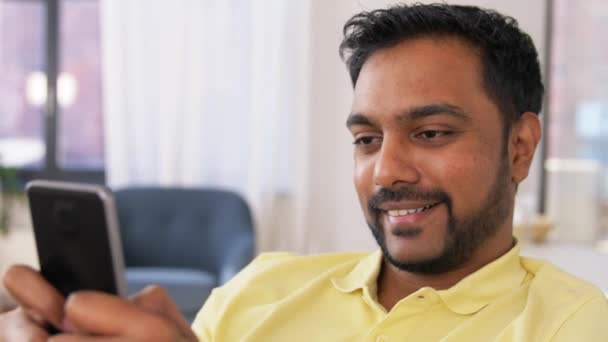 Hombre indio feliz con teléfono inteligente en casa — Vídeos de Stock