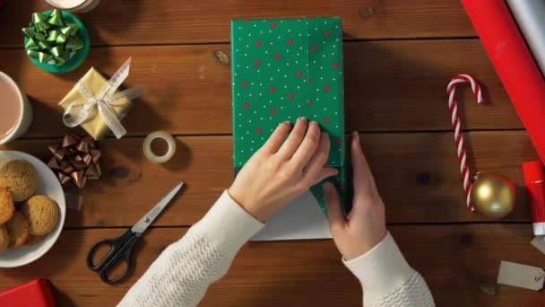 Mujer envolviendo el regalo de Navidad en papel en casa — Vídeos de Stock