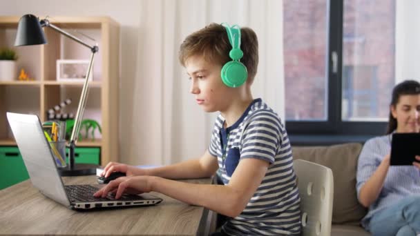 Estudante menino com laptop aprendizagem on-line em casa — Vídeo de Stock