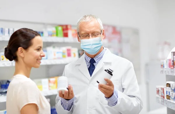 Apothecary and woman with drug at pharmacy — Stock Photo, Image