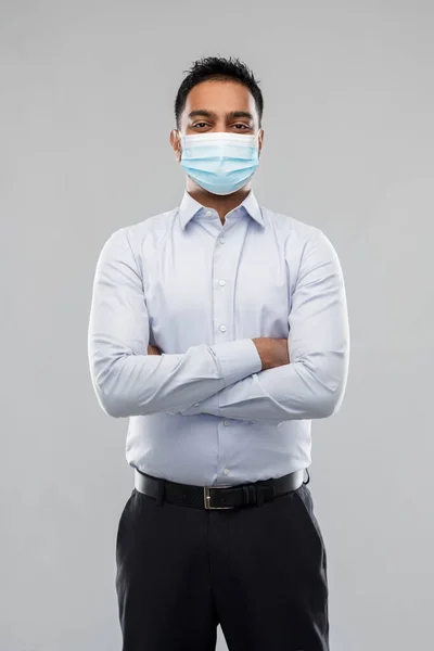 Индийский бизнесмен в маске на сером фоне — стоковое фото