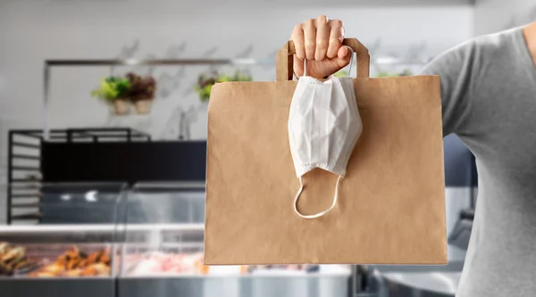 Žena s jídlem v tašce a maskou v obchodě — Stock fotografie