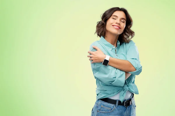 Mulher sorridente com relógio inteligente abraçando-se — Fotografia de Stock