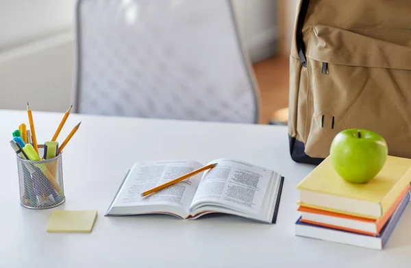 Libros, manzanas y útiles escolares en la mesa en casa —  Fotos de Stock