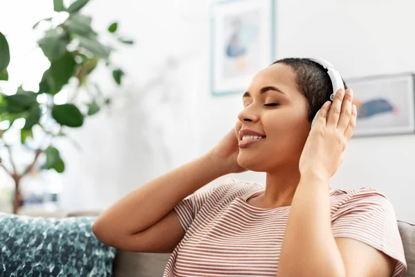 Kobieta w słuchawkach słucha muzyki w domu — Zdjęcie stockowe