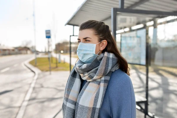 Giovane donna con maschera medica alla fermata dell'autobus — Foto Stock