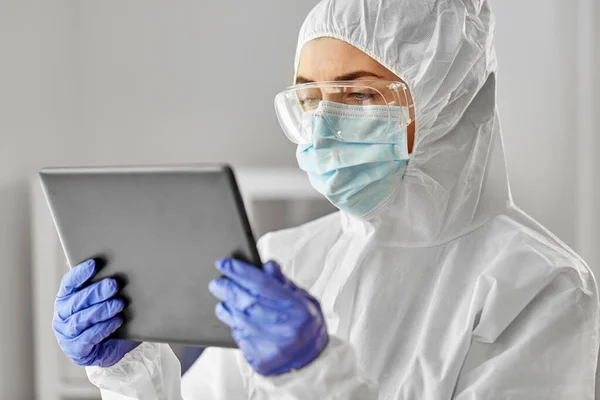 Lékař v ochranném oděvu s počítačem tabletu — Stock fotografie