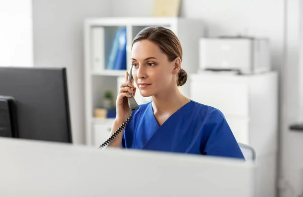 Médecin avec ordinateur appelant au téléphone à l'hôpital — Photo