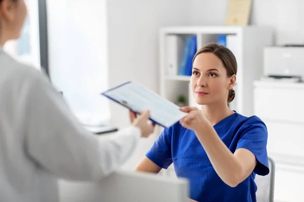 Hastanede panosu olan doktor ve hemşire. — Stok fotoğraf