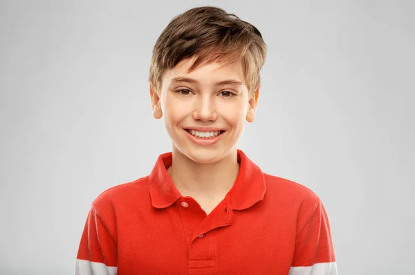 빨간 폴로 티셔츠를 입고 행복하게 웃고 있는 소년의 사진 — 스톡 사진