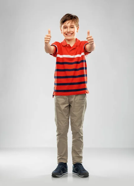 Feliz chico en rojo polo camiseta mostrando los pulgares hacia arriba — Foto de Stock