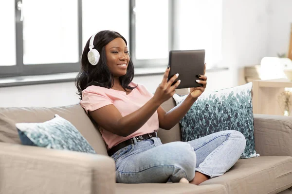 Mujer con tablet pc escuchando música en casa —  Fotos de Stock