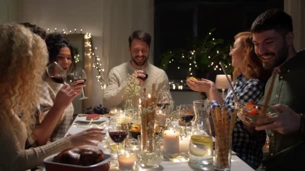 Glückliche Freunde, die auf der Weihnachtsfeier Rotwein trinken — Stockvideo