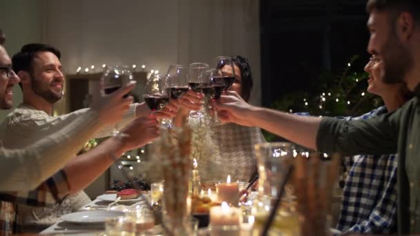 Gelukkig vrienden drinken rode wijn op kerstfeest — Stockvideo