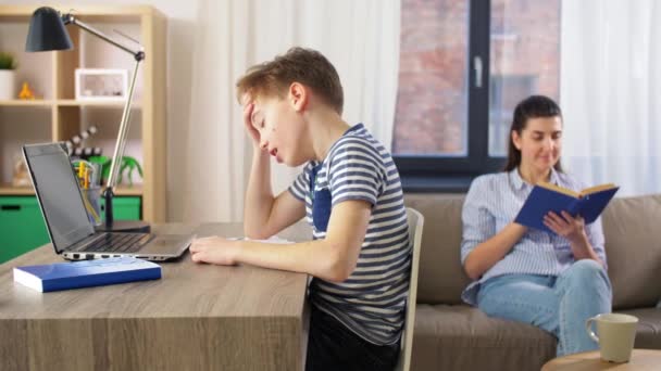 Trött student pojke med bärbar dator lärande hemma — Stockvideo