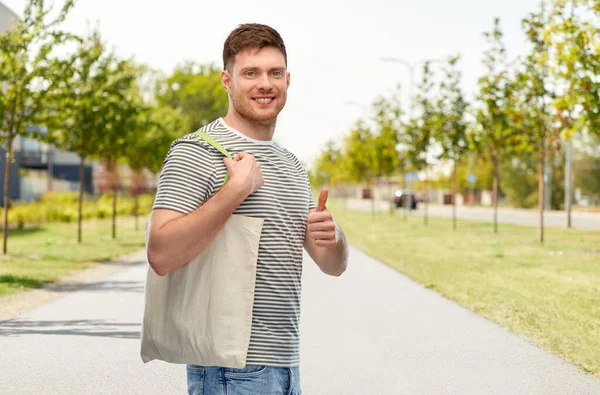 Homem com saco de lona reutilizável para compras de alimentos — Fotografia de Stock