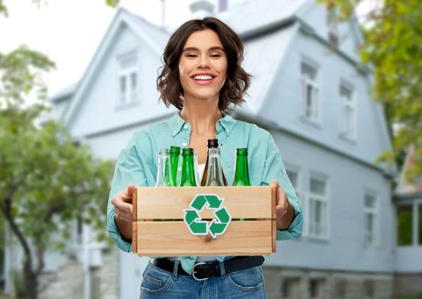 Smiling young woman sorting glass waste outdoors — Stock Photo, Image