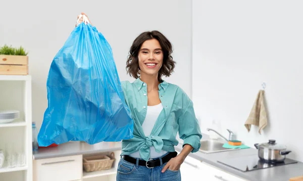 Mujer sonriente sosteniendo bolsa de basura de plástico con residuos — Foto de Stock