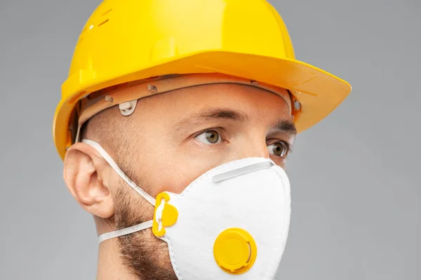 Male worker or builder in helmet and respirator — Stock Photo, Image