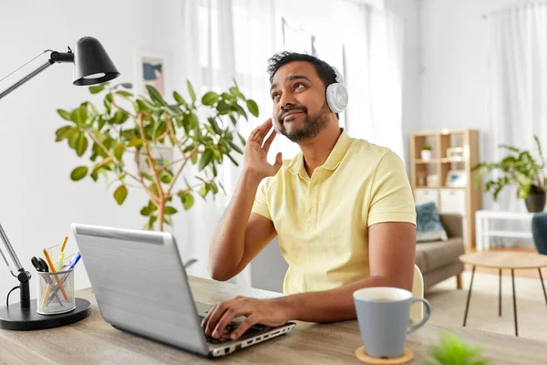 Pria dengan headphone dengan laptop yang bekerja di rumah — Stok Foto