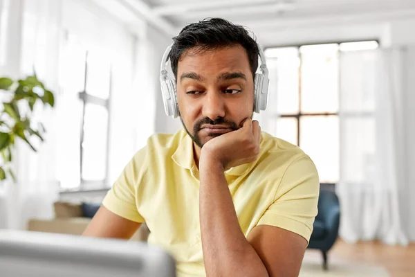 Hombre en auriculares con portátil trabajando en casa —  Fotos de Stock