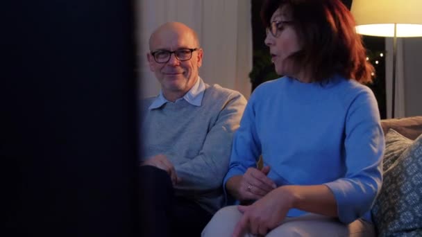Glückliches Senioren-Paar schaut abends zu Hause fern — Stockvideo