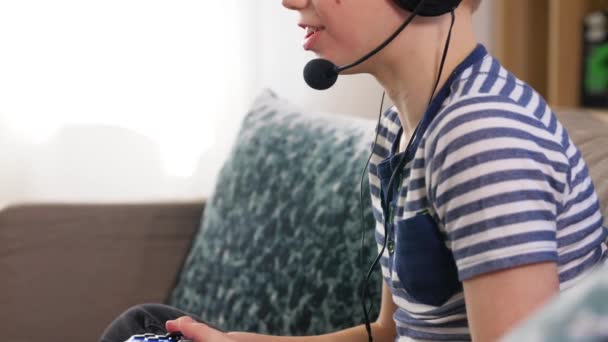 Chico con gamepad jugando videojuego en casa — Vídeos de Stock