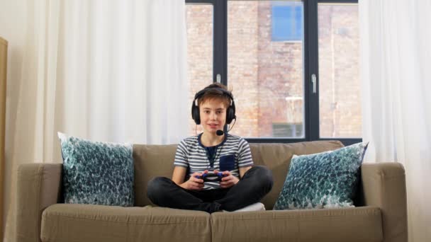 Happy boy with gamepad playing video game at home — Stock Video