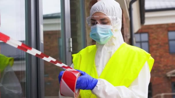 Trabajador de la salud sellando la puerta con cinta de precaución — Vídeos de Stock