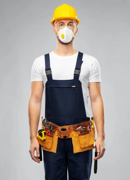 Мужчина или строитель в шлеме и респираторе — стоковое фото