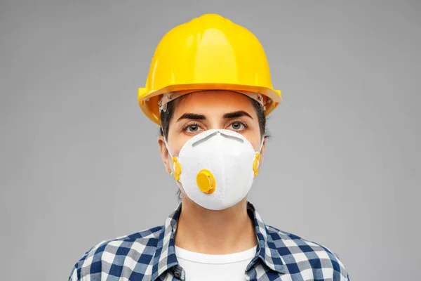 Female worker or builder in helmet and respirator — Stock Photo, Image